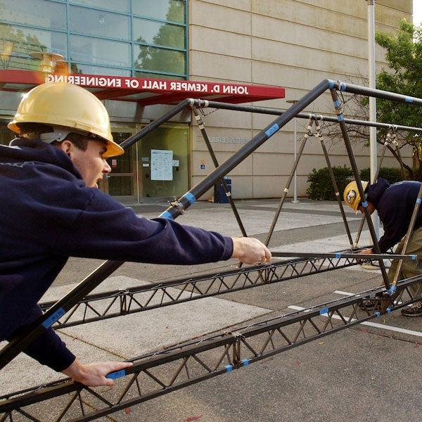 Students build an iron bridge outside of the Engineering complex at UC Davis