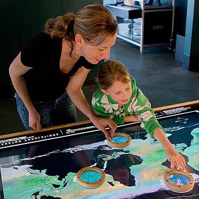 Mother and daughter playing on a lighted surface showing oceans