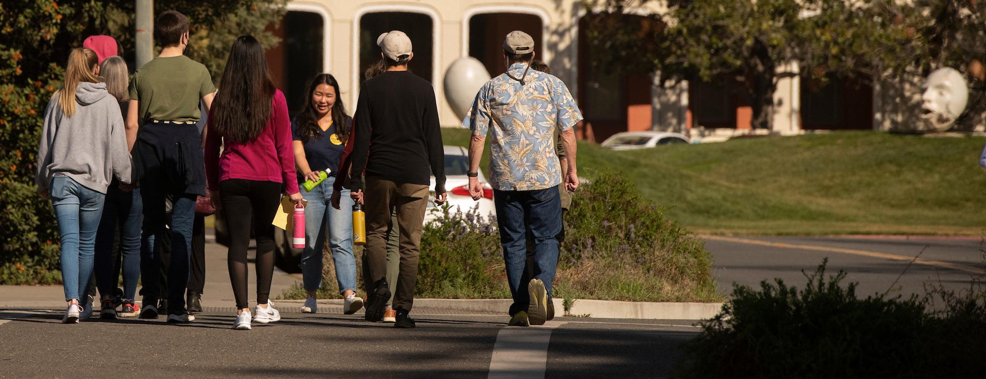 A female UC Davis student walks her audience through the UC Davis campus near Mrak Hall