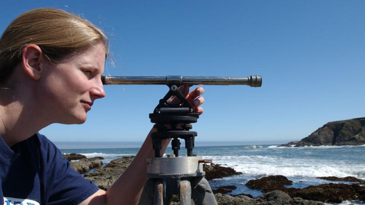 A female researcher surveys the coastline near bodega bay