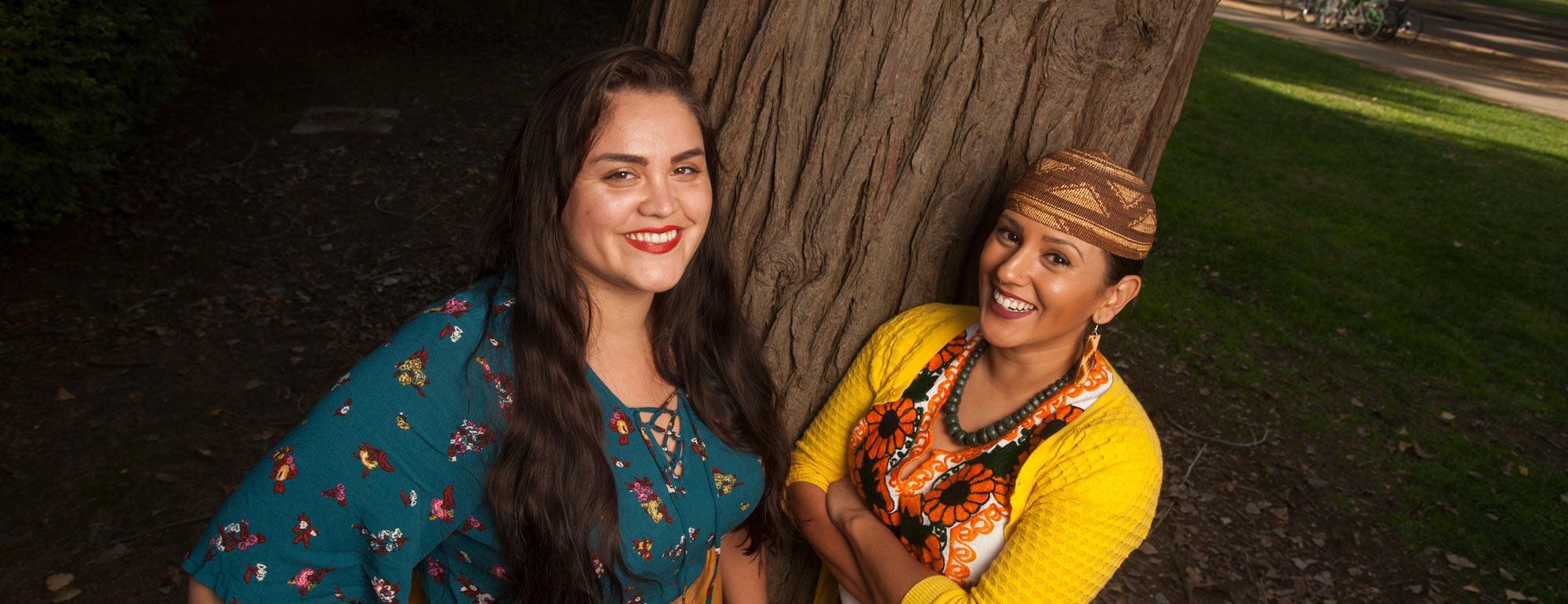 两名女子在amjs澳金沙门的一棵橡树前摆姿势
