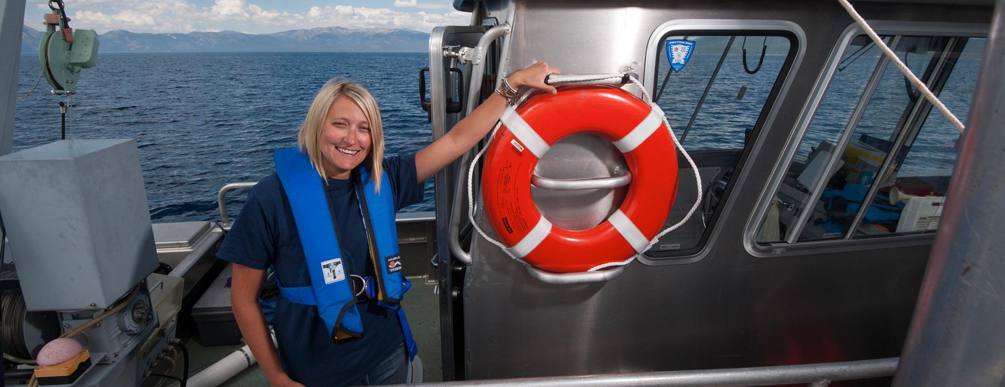 A female researcher poses on a research vessel on Lake Tahoe