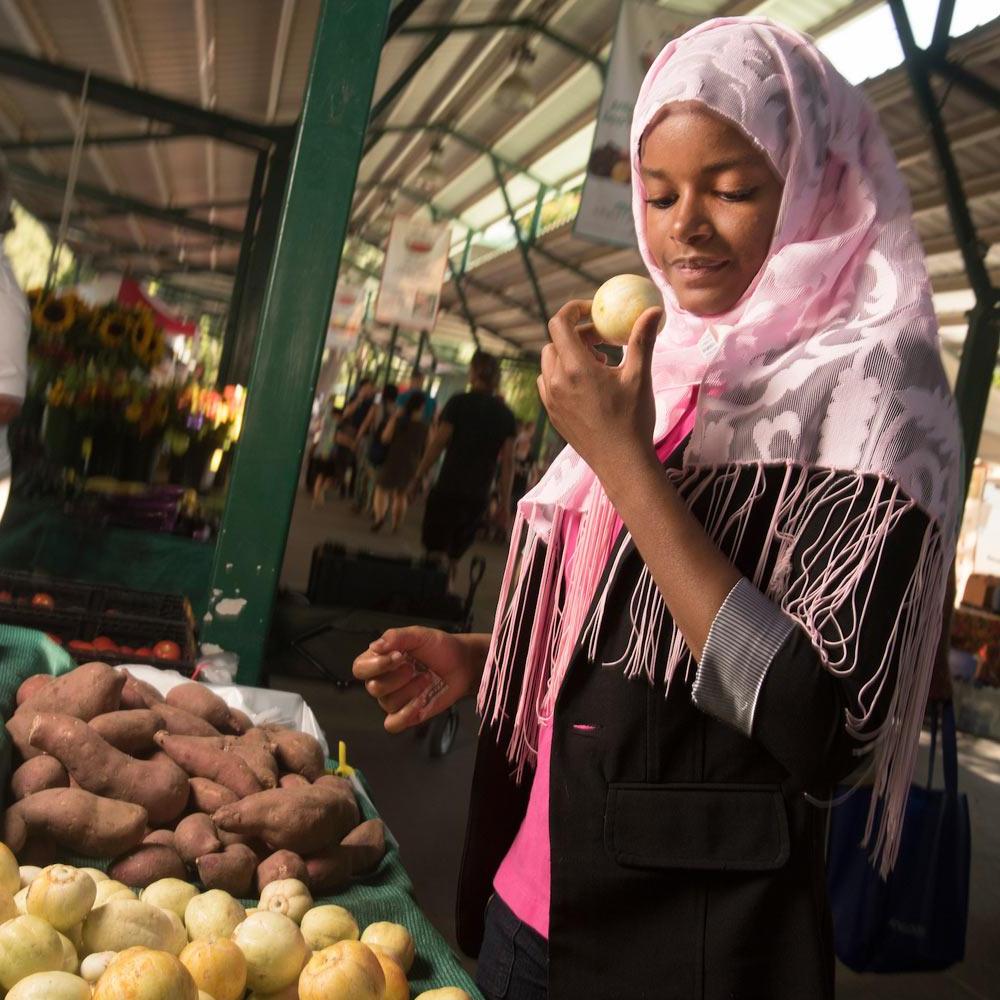 一名amjs澳金沙门的女学生在戴维斯农贸市场浏览新鲜农产品