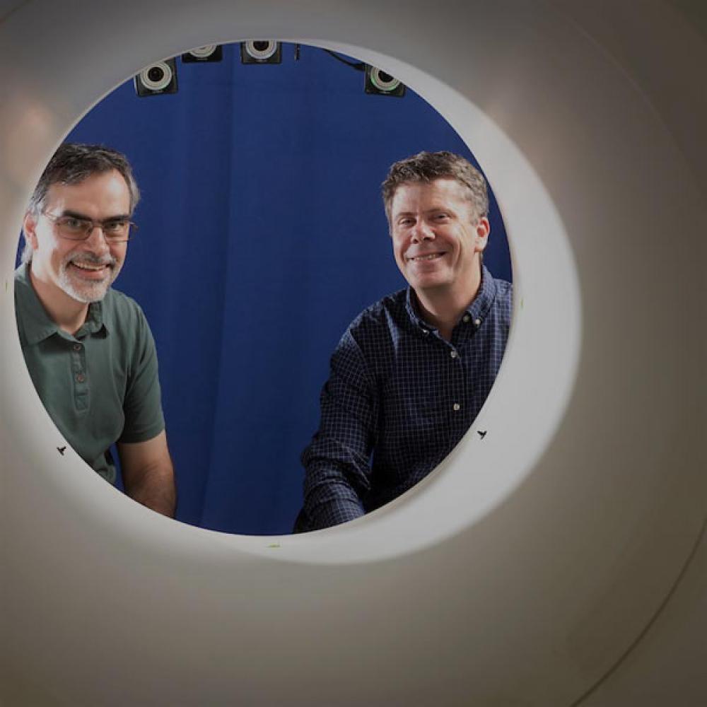 Two researchers stair through the opening to a full body PET scan maching that UC Davis pioneered.
