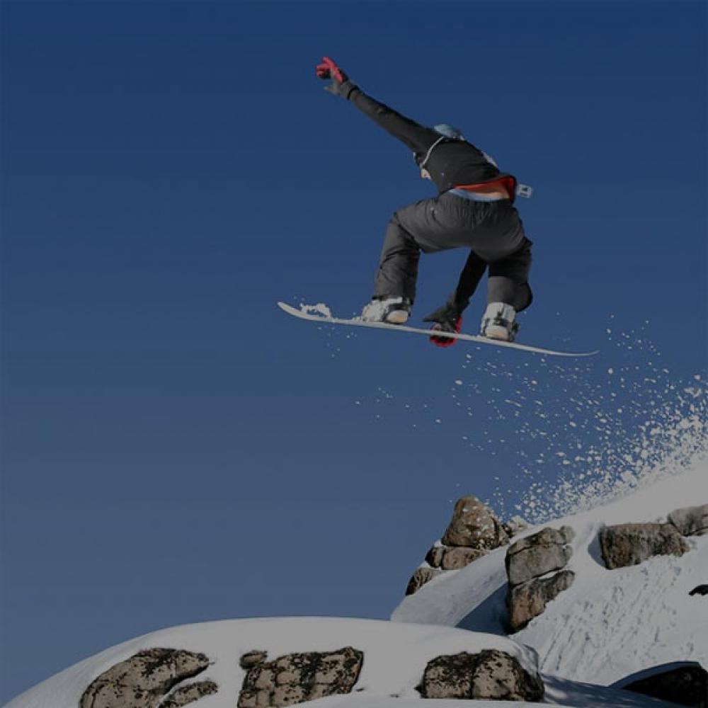 A snowboarder sending it off a mountain top