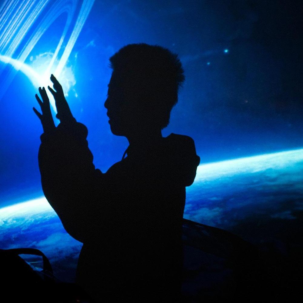 A child interacts with a virtual universe exhibit